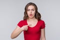 Surprised young brunette woman points to herself index finger, wonders why she was accused of what she did not do Royalty Free Stock Photo