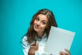 Surprised young business woman with pen and tablet for notes on blue background Royalty Free Stock Photo