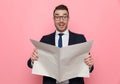 Surprised young fashion model smiling and reading newspaper Royalty Free Stock Photo