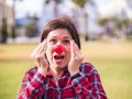 Surprised young girl with a clown nose. Joke, humor and funny portrait concept. April fools day. Royalty Free Stock Photo