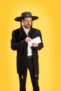 Surprised young Jewish man holds letter with invitation on celebrating Purim holiday from his friend against sunny Royalty Free Stock Photo