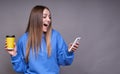 A surprised young lady looks into her smartphone Royalty Free Stock Photo