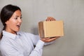 Surprised young lady opening a package Royalty Free Stock Photo