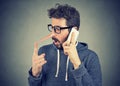 Surprised young man with long nose talking on mobile phone Royalty Free Stock Photo