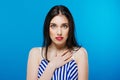 Surprised young pretty girl looking at the camera isolated on the blue background