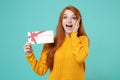 Surprised young redhead woman girl in yellow knitted sweater posing  on blue turquoise wall background. People Royalty Free Stock Photo