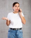 Surprised young woman talking on mobile phone Royalty Free Stock Photo