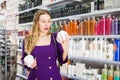 Surprised young woman choosing hair care products at cosmetics store Royalty Free Stock Photo