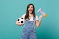 Surprised young woman football fan support favorite team with soccer ball, megaphone isolated on blue turquoise Royalty Free Stock Photo