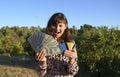 Surprised young woman hold credit bank card fan of money in dollar banknotes cash money Royalty Free Stock Photo