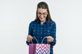 Surprised young woman looking shopping bag, white background Royalty Free Stock Photo