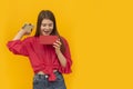 Surprised young woman with an open gift box and looks admiringly into it.Yellow background. Girl received gift