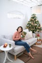 Surprised young woman opening gift box near christmas tree Royalty Free Stock Photo