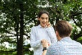 Surprised young woman and smiling while her boyfriend marriage proposing in the park. marry me. love, couple, date, wedding -