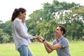 Surprised young woman and smiling while her boyfriend marriage proposing in the park. marry me. love couple, date and wedding