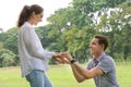 Surprised young woman and smiling while her boyfriend marriage proposing in the park. marry me. love couple, date and wedding