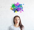 Surprised young woman on white brick background with colorful brain sketch.