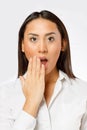 Surprised young woman with wide open eyes covering mouth with her hand Royalty Free Stock Photo