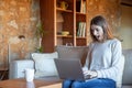 Surprised young woman writing in front of the laptop sitting on the sofa Royalty Free Stock Photo