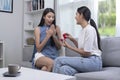 Surprised young woman with raising her hands and smiling while her girlfriend proposing her . Emotional couple in love Royalty Free Stock Photo