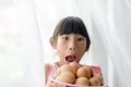 Surprising girl holding eggs bowl with white