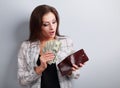 Surprising happy woman holding dollars and looking in wallet and Royalty Free Stock Photo