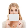 Surprising message. Studio portrait of a woman holding a blank sign in front of her mouth isolated on white. Royalty Free Stock Photo