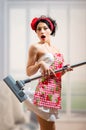 Surprized sexi pinup girl holding vacuum cleaner