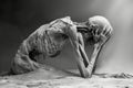 Surreal Black and White Imagery of Emaciated Humanoid Figure in Desert Evoke Loneliness and Desolation Royalty Free Stock Photo
