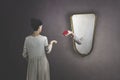 Surreal gesture of a hand coming out of the mirror to give a rose to a woman Royalty Free Stock Photo