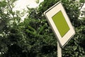 Surreal green color traffic sign concept with lush foliage - social issues concept with copy space. Close-up of right of way sign.