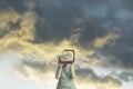 Surreal illustration of a woman with her head hidden by a tv projecting a sky