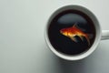 Surreal Image of Goldfish Swimming in Coffee Cup on White Background Royalty Free Stock Photo