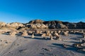 Late afternoon sunlight on an alien landscape of unusual rock formations and boulders in the Bisti Badlands of New Mexico Royalty Free Stock Photo