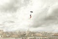 Surreal moment of a woman flying with her umbrella over the city Royalty Free Stock Photo
