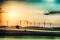 Surreal morning sunrise on the fields with wind turbines in the background