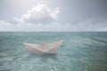 Surreal paper boat travels alone in the infinite ocean