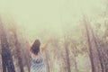 Surreal photo of young woman standing in forest. image is textured and toned. dreamy concept