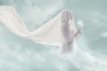 Surreal portrait of bride in clouds hold jellyfish