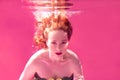 Surreal portrait of young attractive woman underwater in colorful water Royalty Free Stock Photo
