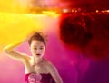 Surreal portrait of young attractive woman underwater in colorful water Royalty Free Stock Photo