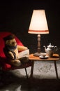 Teddy bear read a book outside in a winter night - surreal scene Royalty Free Stock Photo