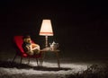 Teddy bear read a book outside in a winter night - surreal scene Royalty Free Stock Photo