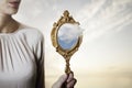 Surreal situation of a cloud coming out of a mirror held by a woman Royalty Free Stock Photo