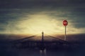 Surreal view as man walks a crushing asphalt road as STOP red sign warns of danger. Deep hole in the ground, chasm as broken way Royalty Free Stock Photo