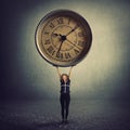 Surreal view as a tiny girl teenager lifting a huge clock over head. Student time management concept. Educational process hours,