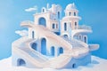 A surreal white and blue architectural structure with multiple staircases, arches, and balconies against a clear blue sky Royalty Free Stock Photo