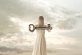 Surreal woman shows a key to open all doors of life, freedom, success, happiness Royalty Free Stock Photo