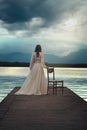 Surreal woman waiting on lake pier Royalty Free Stock Photo