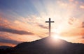 Surrender concept: Silhouette of crucifix cross on mountain at sunset time with holy and light background